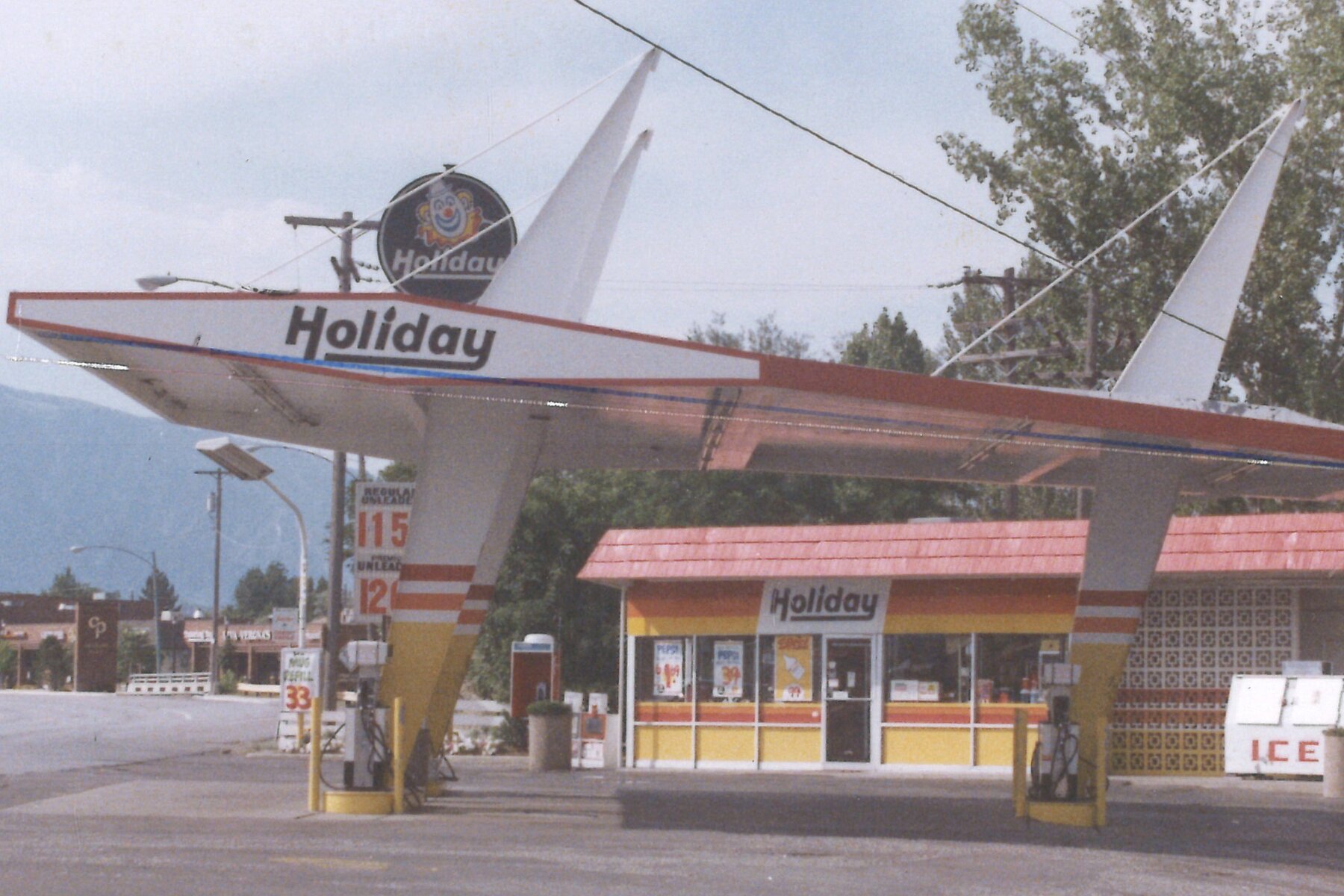 Vintage Holiday station with its swooping winged canopy and clown sign